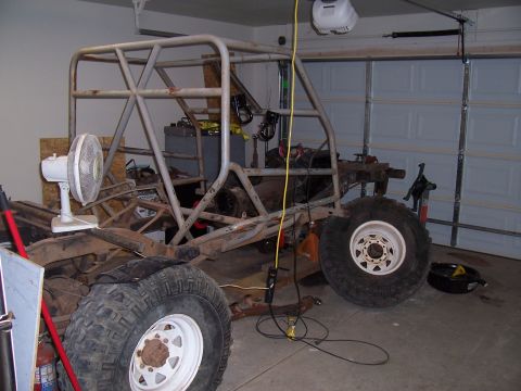 2003 Ford Ranger - Unfinished off-road vehicle chassis with a roll cage is in a garage.
