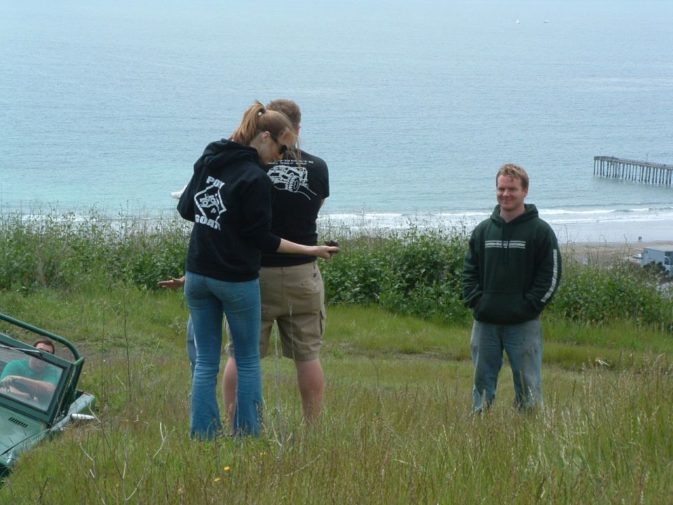 Green Jeep YJ parked on grassy hill overlooking ocean