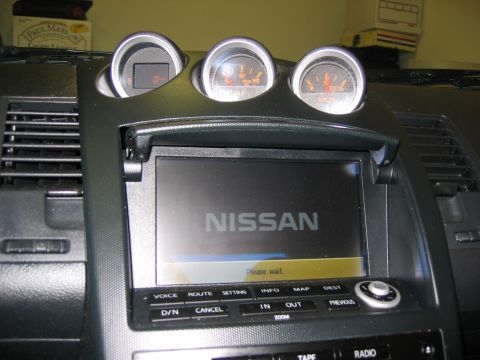 2004 Nissan 350Z - Close-up of a Nissan infotainment system and dashboard gauges.