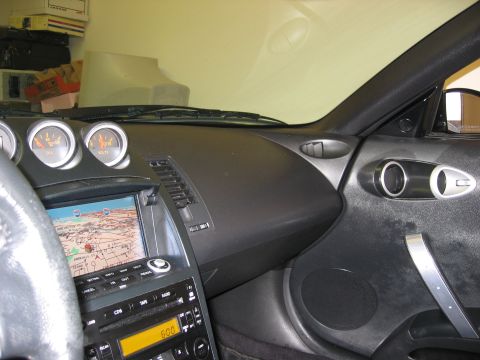 2004 Nissan 350Z - The interior of a car, the dashboard with gauges and a navigation system display.