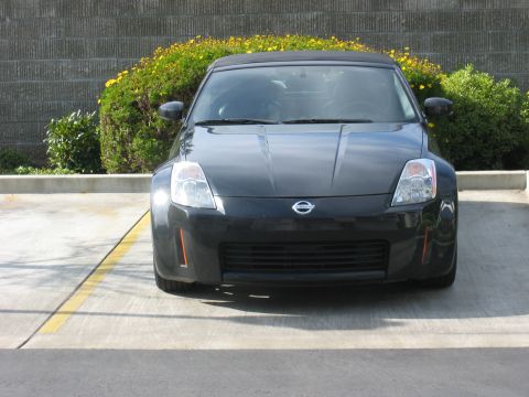 2004 Nissan 350Z - Front view of a black Nissan 350Z convertible parked in a lot.