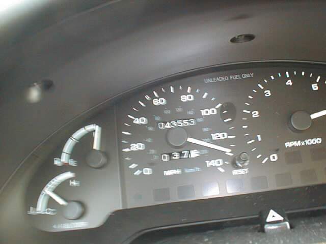 Analog gauge cluster with speedometer, tach, and odometer reading 043553