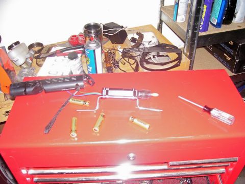 1991 Ford Bronco - Various electronic parts and batteries are laid out on a red toolbox, suggesting a repair or assembly project.