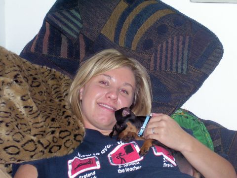 1991 Ford Bronco - A woman smiles while holding a small dog on her chest, with a patterned blanket in the background.