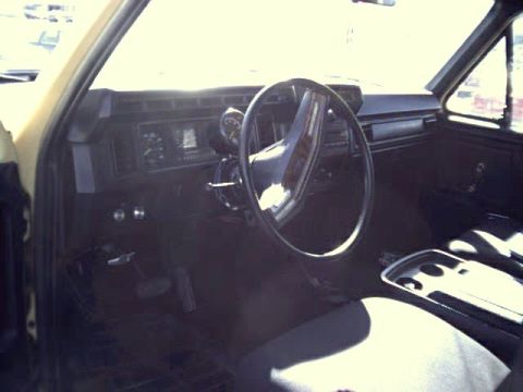 1982 Ford Bronco - The interior of the vehicle features a dashboard with gauges and a steering wheel, along with the front seats.