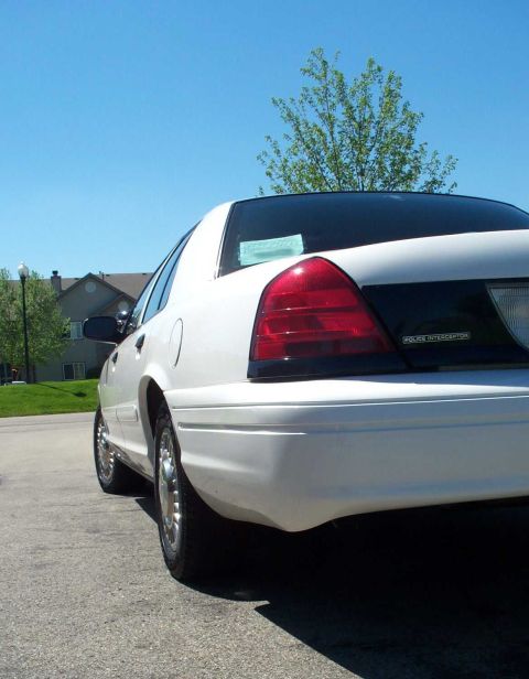 2001 Ford Crown Victoria - Rear view of a white 2001 Ford Crown Victoria with a black stripe across the trunk.