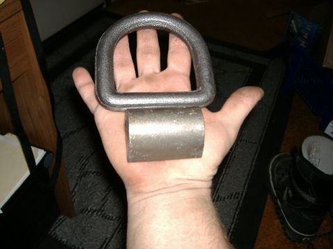 1979 Ford Bronco - Metal tie-down ring and cylinder shown in hand for scale.