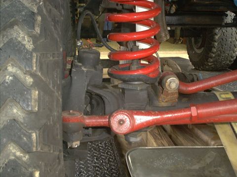 1978 Ford Bronco - Off-road vehicle suspension detail, showing red coil spring and steering linkage.