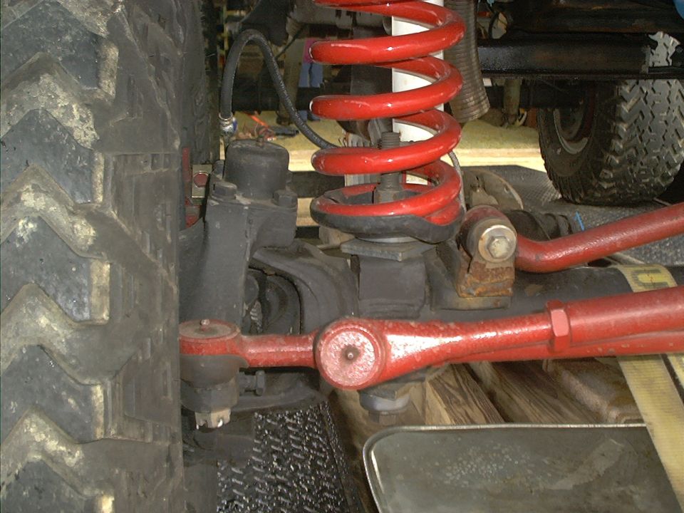 Close-up of red coil spring and suspension components on an off-road vehicle