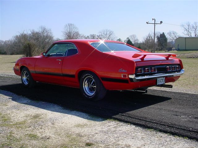 Red 1970 coupe utility vehicle with spoiler and black stripe