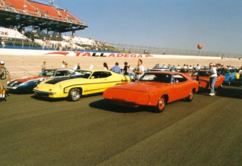 1972 Ford Ranchero - Multiple classic cars line up on a racetrack, with grandstands in the background.