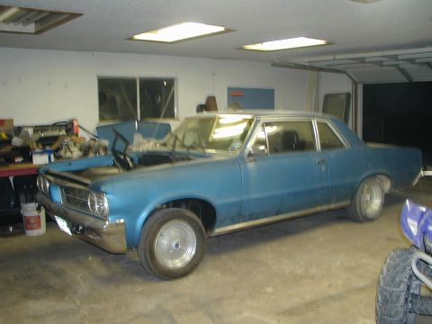 1964 Pontiac Tempest - This 1964 Pontiac Tempest is in a garage with its hood open, revealing the engine bay.