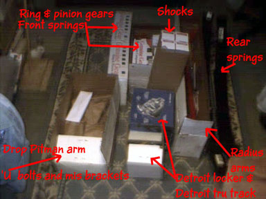 1996 Ford Bronco - Various auto parts are laid out on the floor, labeled with red text indicating their function.