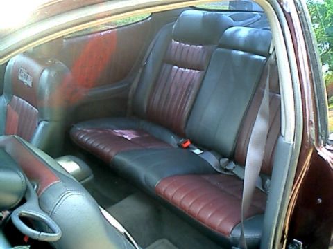 2002 Pontiac Grand Prix - The interior of a car shows the back seat with dual-tone leather upholstery and seat belts.