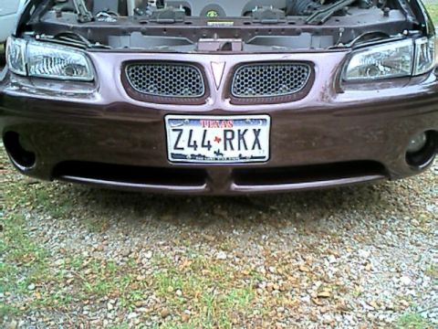 2002 Pontiac Grand Prix - The front grille and headlights of a brown 2002 Pontiac Grand Prix are visible, with a Texas license plate.