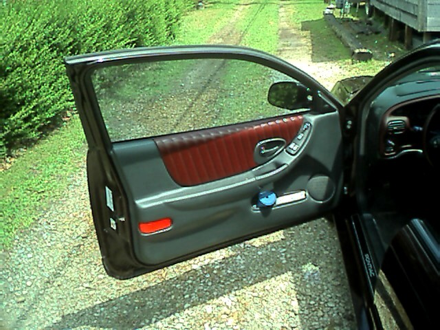 2002 Pontiac Grand Prix interior door panel with red upholstery and gray trim