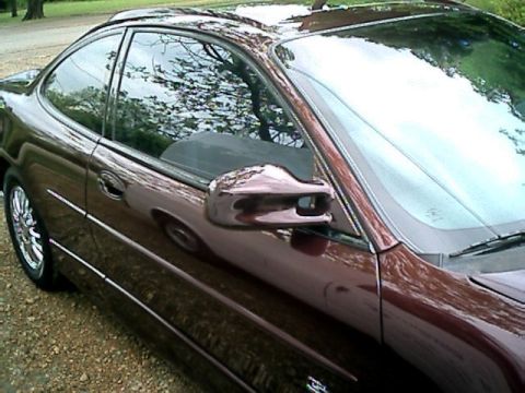 2002 Pontiac Grand Prix - The driver's side of a maroon 2002 Pontiac Grand Prix coupe is shown from a 3/4 front angle.