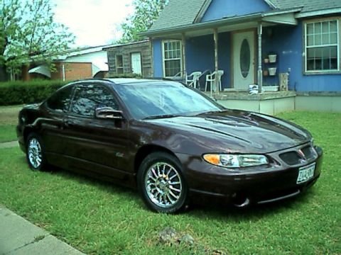 2002 Pontiac Grand Prix - A 2002 Pontiac Grand Prix coupe is parked on a grassy lawn in front of a blue house.
