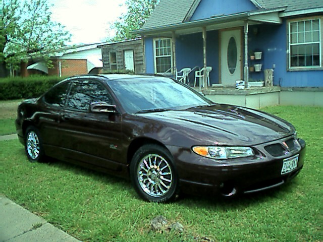 Dark red 2002 Pontiac Grand Prix coupe parked on grass, front 3/4 view