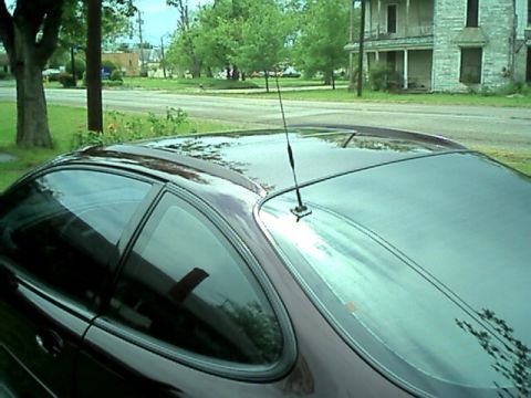 2002 Pontiac Grand Prix - The rear quarter panel and roofline of a dark red 2002 Pontiac Grand Prix coupe are visible.