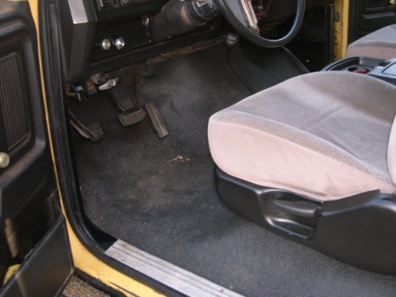 1982 Ford Bronco - Interior view of a 1982 Ford Bronco, focusing on the driver's side floor and seat.