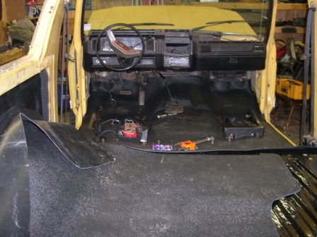 1982 Ford Bronco - The interior of a yellow 1982 Ford Bronco is shown with the dashboard and floor coverings removed for renovation.