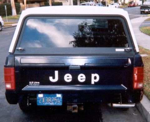 1986 Jeep Comanche - Rear view of a 1986 Jeep Comanche pickup truck, equipped with a white camper shell.
