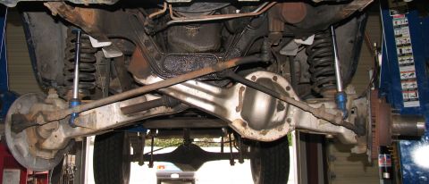 1984 Ford Bronco - Undercarriage view shows the rear axle and suspension system of a vehicle.