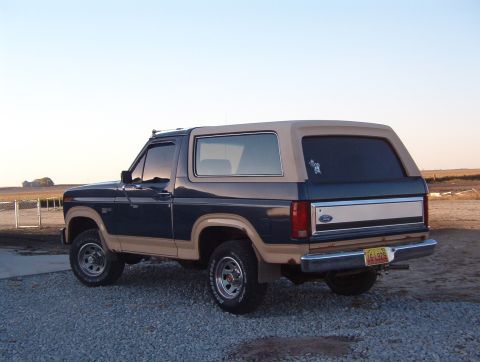 1986 Ford Bronco - This Ford Bronco features a two-tone paint scheme with a removable tan top and a chrome bumper.