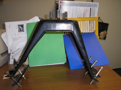 1996 Toyota 4Runner - A black metal automotive part is displayed on a desk, surrounded by office supplies and documents.