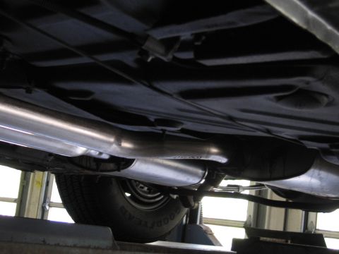 1978 Dodge Monaco - The undercarriage of a vehicle, a dual exhaust system and a tire visible.