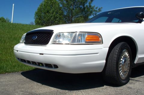 2001 Ford Crown Victoria - The front quarter of a white Ford Crown Victoria is shown parked outdoors on a sunny day.