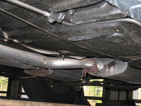 1978 Dodge Monaco - Underside view of a car's exhaust system, showing mufflers and pipes. A tire is visible.