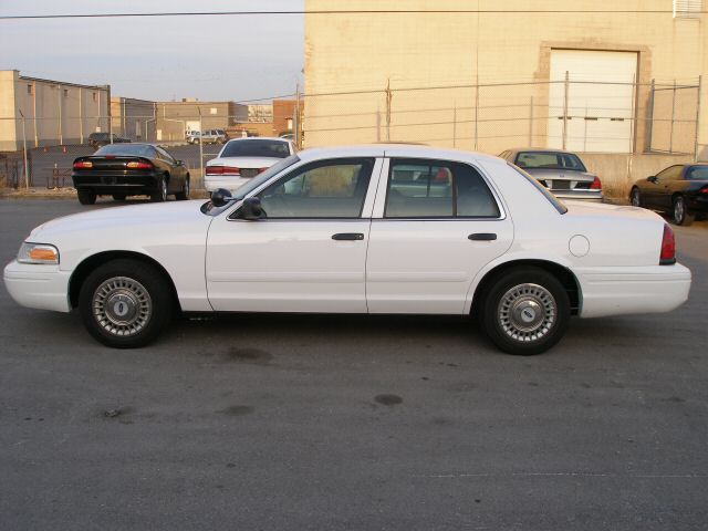 2001 Ford Crown Victoria parked on asphalt, side view. Other cars and buildings in background