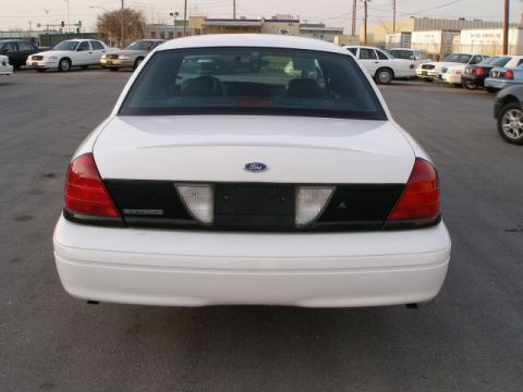 2001 Ford Crown Victoria - Rear view of a white 2001 Ford Crown Victoria, showing its taillights and black trim panel.