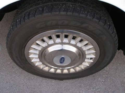 2001 Ford Crown Victoria - Close-up of a Ford wheel cover on a Goodyear tire.