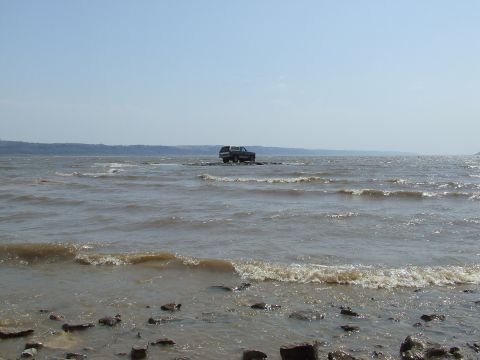 1986 Ford Bronco - Ford Bronco sits on a rocky island in the middle of a body of water.