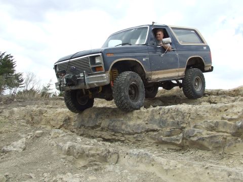 1986 Ford Bronco - A driver navigates a rocky terrain in a modified Ford Bronco, its off-road capabilities.