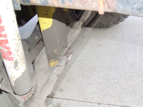 1986 Ford Bronco - Undercarriage view shows mud-caked suspension components and a tire.