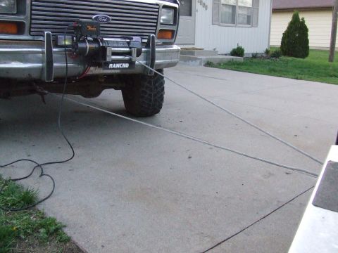 1986 Ford Bronco - Front view of a Ford truck with a winch mounted on the bumper, connected to a tow cable.