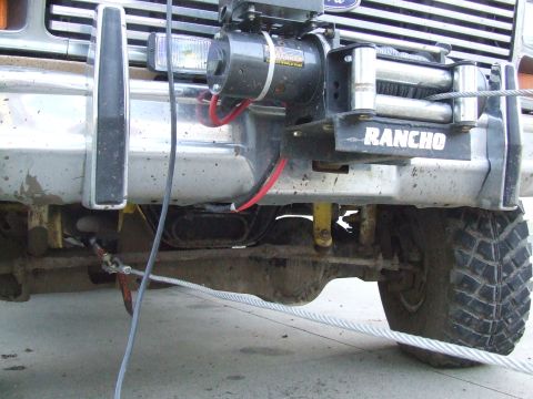 1986 Ford Bronco - Front view of a 1986 Ford Bronco, a Rancho winch mounted on the bumper and a tow cable attached.
