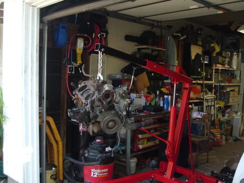 1993 Ford Taurus - Engine hoist suspending an engine in a garage. The registry claims it is a 1993 Ford Taurus, but this is unconfirmed.