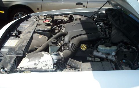 2001 Ford Crown Victoria - Engine bay of a white 2001 Ford Crown Victoria, with "ANTI Check GREEN" written on the air intake housing.