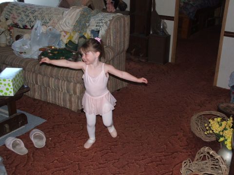 1966 Ford Ranchero - A young girl in a ballet outfit practices her moves in a carpeted room, with a couch in the background.