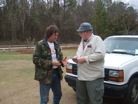 1966 Ford Ranchero - Two men converse next to a white SUV in an outdoor setting.