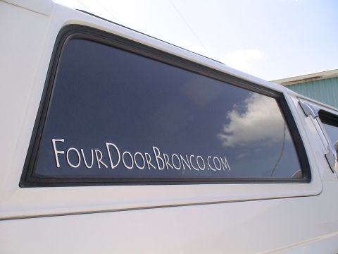 1993 Ford C-350 (Centurion Conversions) - A white vehicle has a website address for a four-door Bronco conversion on its window.
