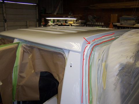1993 Ford C-350 (Centurion Conversions) - A white van's roofline is prepared for painting, with masking tape and paper covering the windows and body panels.