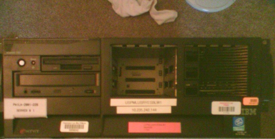 IBM server computer with drive bays and internal components visible, labels attached