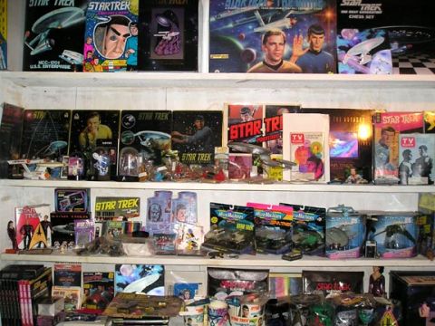 1984 Pontiac Fiero - A collection of Star Trek merchandise displayed on shelves, various toys and collectibles.