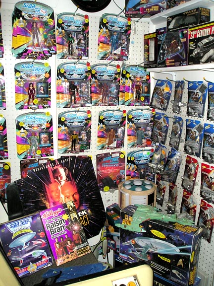 1984 Pontiac Fiero - A collection of Star Trek toys and memorabilia is displayed on a wall and shelves.